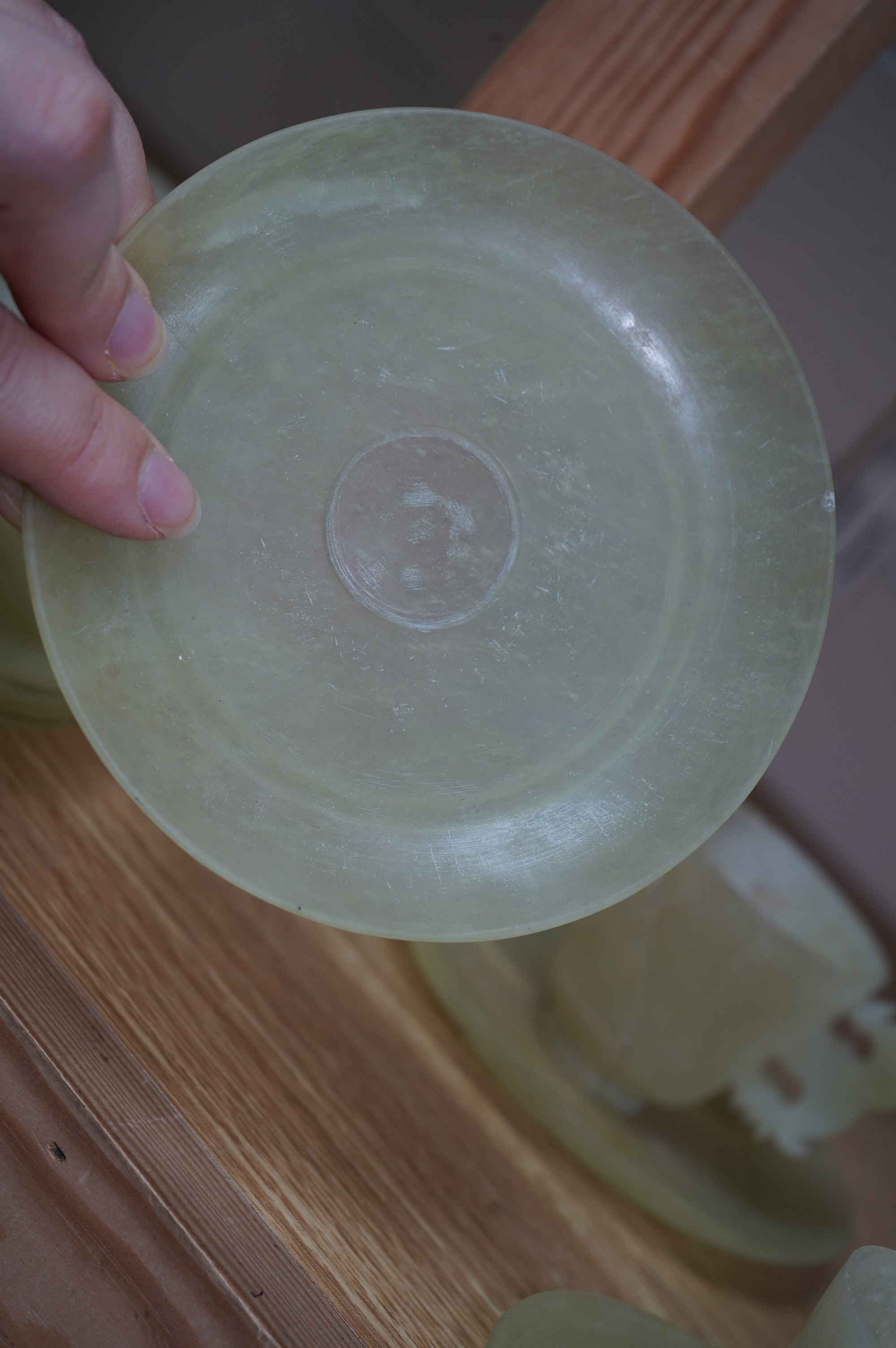 A set of seven Chinese bowenite jade cups and eight saucers, 11cm in diameter. Condition - fair to good